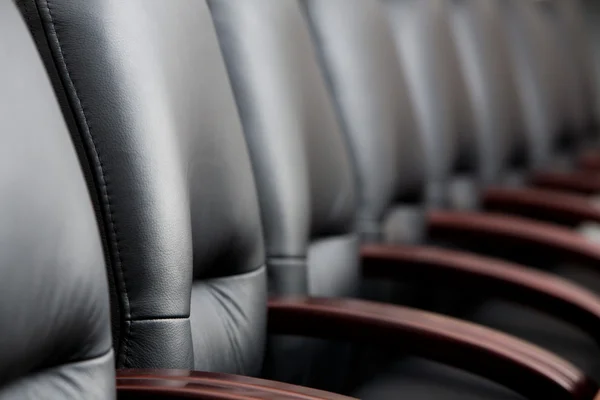 Fila de cadeiras pretas de couro em uma sala de reuniões — Fotografia de Stock