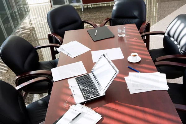 Sala de reuniões vazia: cadeiras pretas em torno da mesa com objetos de negócios — Fotografia de Stock