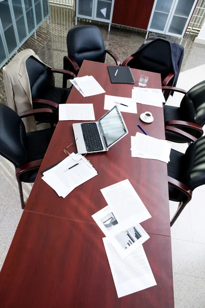 Empty boardroom: black chairs around table with business objects on it — Stock Photo, Image