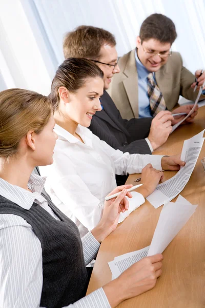 Four businesspeople sitting at table, and interacting — Stock Photo, Image