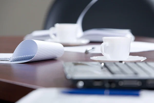Documents d'affaires, ordinateur portable et tasse de café sont couchés sur la table — Photo