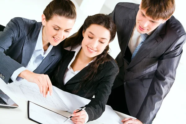 Image of three happy business looking at business plan with smiles — Stock Photo, Image