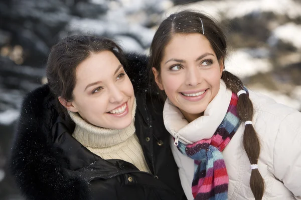 Две улыбающиеся девушки играют в зимнем лесу — стоковое фото