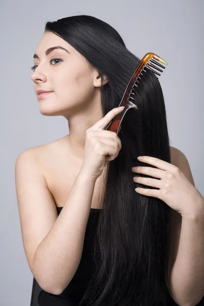 Frau macht ihr schönes dunkles Haar — Stockfoto
