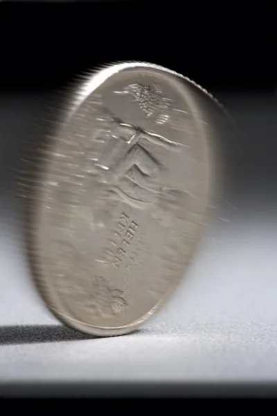 Вращающаяся монета на столе . — стоковое фото