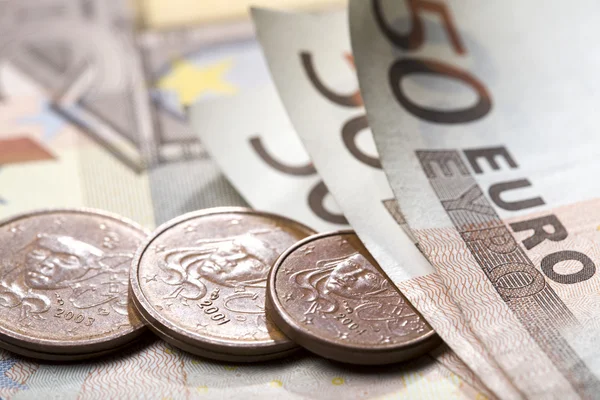 Monete in euro sul fondo monetario delle banconote — Foto Stock