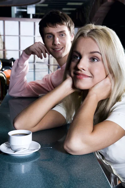 Smiling cute blond woman drinking coffee in the bar — Stock Photo, Image