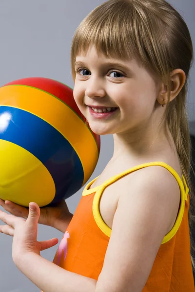 灰色微笑着金发女孩在橙色礼服用多彩多姿的球上孤立 — 图库照片