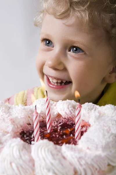 Счастливый блондин с праздничным тортом смотрит на свечи — стоковое фото
