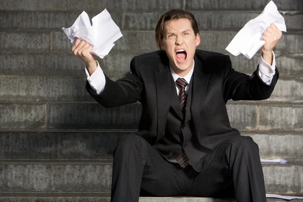 Zdjęcie biznesmen krzyk z dwóch arkuszy papieru w ręce — Zdjęcie stockowe