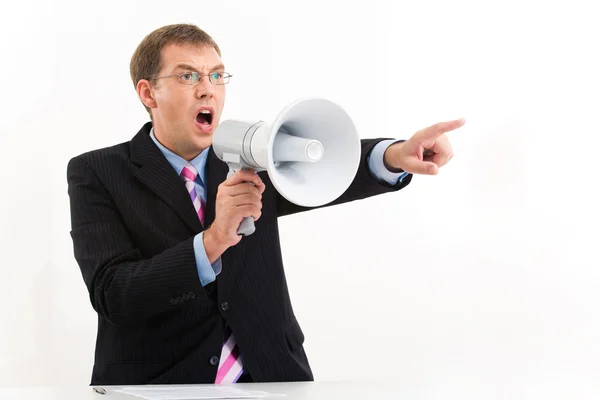 Homem infeliz de terno falando através de megafone e apontando para o lado — Fotografia de Stock