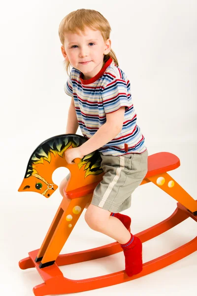 Мальчик на игрушечной лошади — стоковое фото