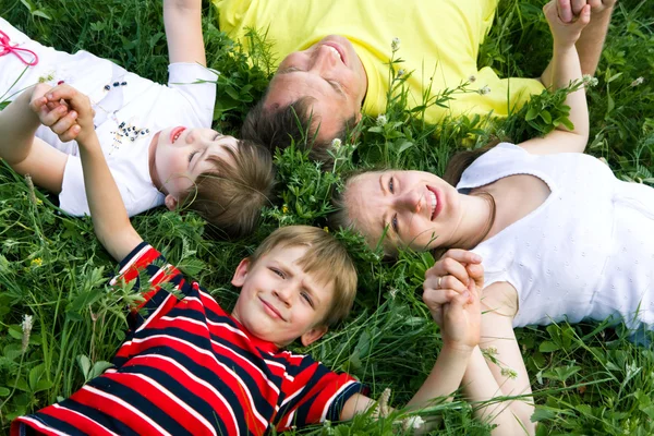 Bilden av leende unga pojkar och flickor leker i gräset — Stockfoto