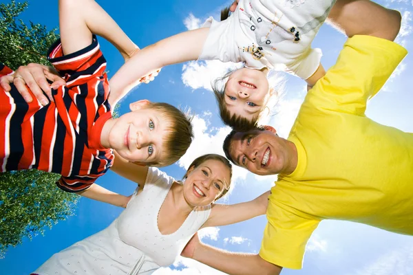 Rodzinny zespół uśmiechający się z pochmurnego nieba powyżej — Zdjęcie stockowe