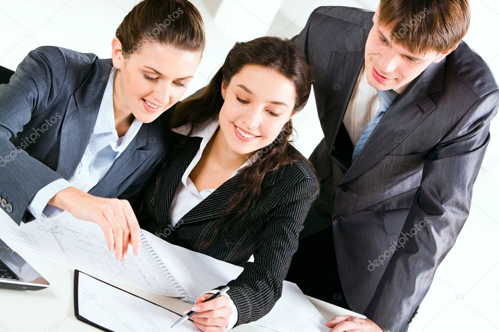 Image of three happy business looking at business plan with smiles