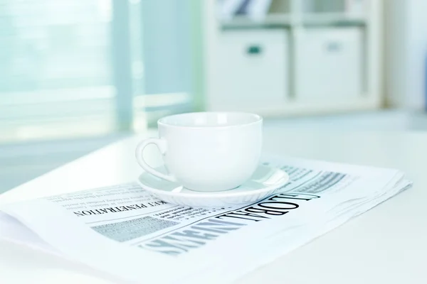 Cup en zakelijke krant — Stockfoto
