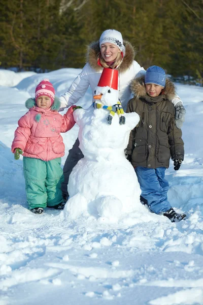Família com boneco de neve — Fotografia de Stock