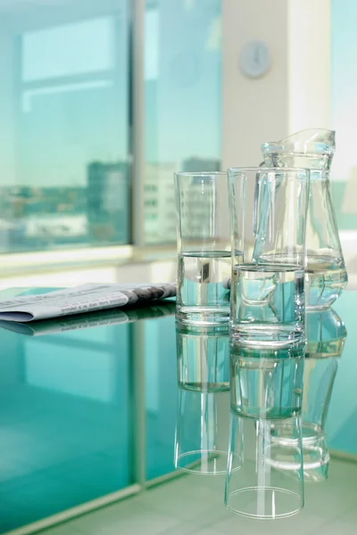 Vatten och tidningen på bordet — Stockfoto