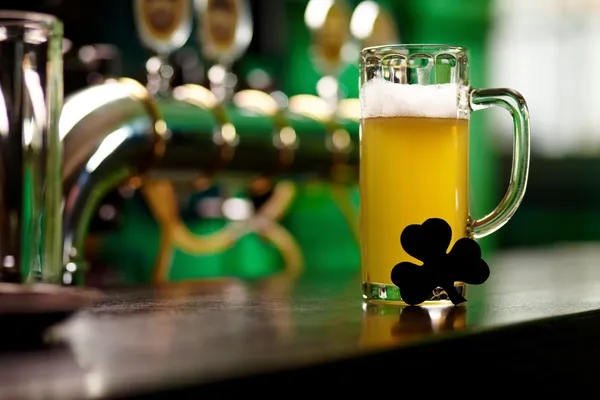 Glass of beer with shamrock leaf — Stock Photo, Image
