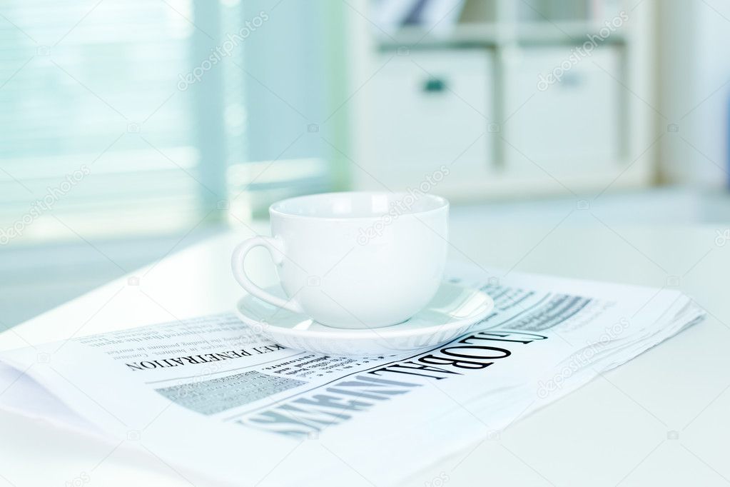 Cup and business newspaper