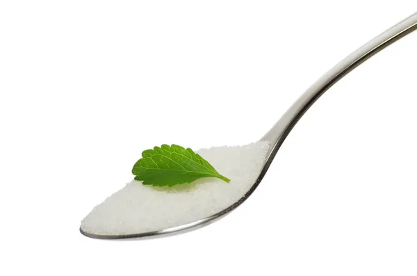 Чайная ложка с сахаром и листом стевии — стоковое фото