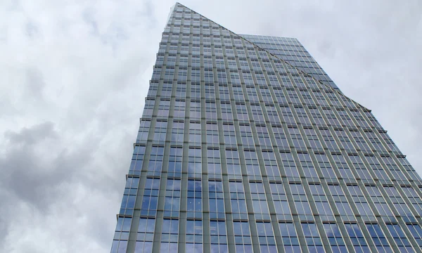 Glazen gebouw tegen wolken in schemerlicht — Stockfoto
