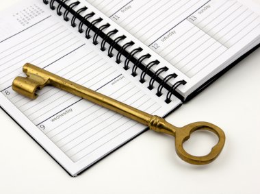 Golden Key On A Daily Planner clipart