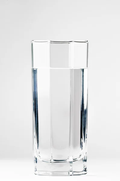 Со стаканом воды на белом фоне — стоковое фото