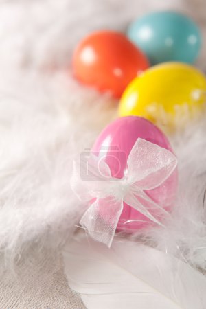Oeufs de Pâques colorés sur fond de plume 