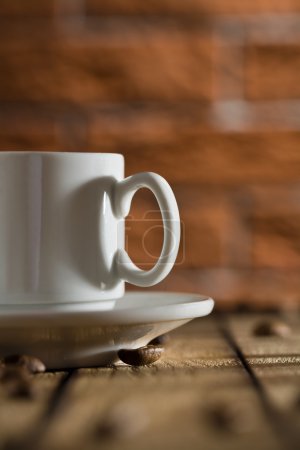 tasse de café blanche sur un fond de mur de briques 