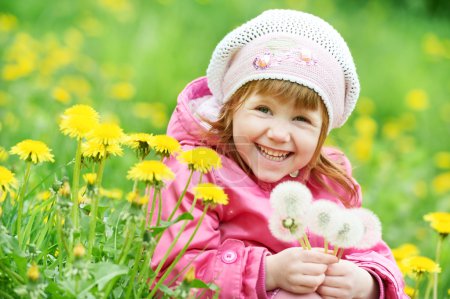 Petite fille enfant avec le pissenlit de printemps 