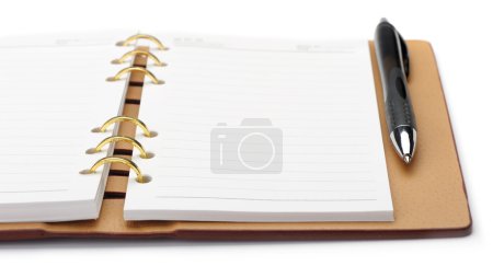 Carnet ouvert avec reliure en cuivre et stylo élégant 