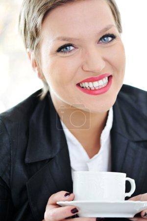 Portrait de femme d'affaires gaie tenant tasse de café 