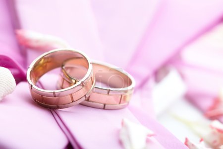 bagues dorées et pétales de rose 