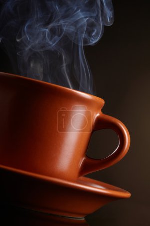 Tasse de café avec fumée sur fond sombre 