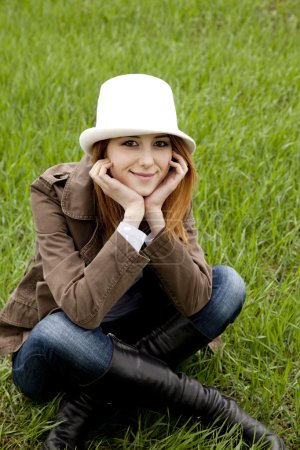 Jeune fille de la mode en chapeau blanc à l'herbe de printemps vert .