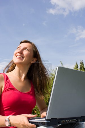 La fille avec ordinateur portable sur la nature 