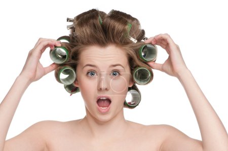 Femme bouclant ses cheveux avec rouleau 
