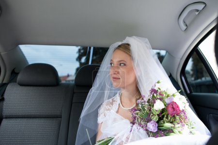 Portrait d'une belle jeune mariée en attente dans la voiture 