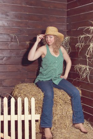 Portrait de fille blonde en chapeau de cow-boy sur fond de balles de paille .