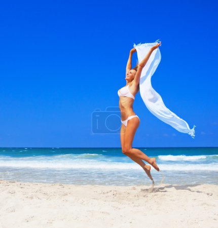 Sauter fille heureuse sur la plage 