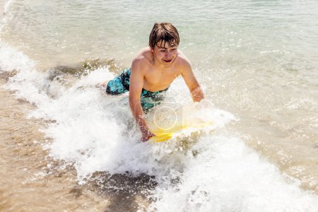 Happy boy aime surfer dans les vagues 