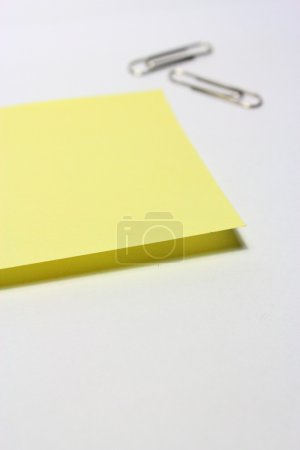 Note jaune avec clip sur fond blanc 