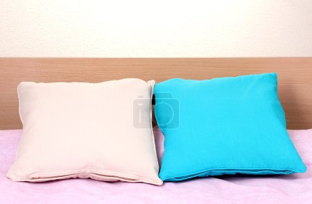 oreillers lumineux sur le lit sur fond beige 