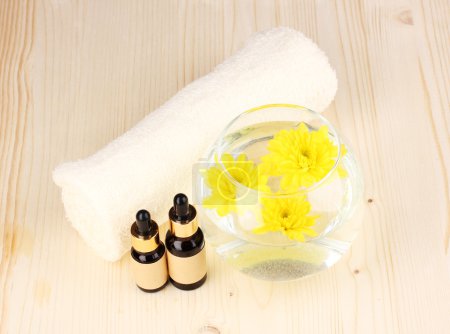 Vase aux fleurs jaunes, décor spa sur fond bois 