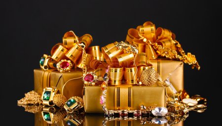Divers bijoux en or et cadeaux sur fond noir 