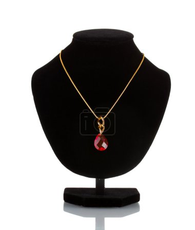 Pendentif avec gemme rouge sur mannequin isolé sur blanc 