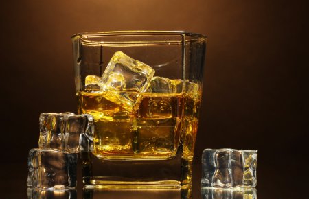 verre de whisky écossais et de glace sur fond brun 