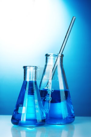 Tubes à essai avec liquide bleu sur fond bleu 