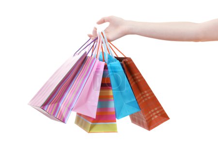 Main féminine tenant des sacs à provisions lumineux isolés sur blanc 